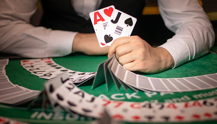 Live Blackjack male dealer holding cards